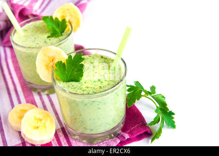 Cold green smoothie with banana, yougurt, herbs and vegetables isolated on white background Stock Photo