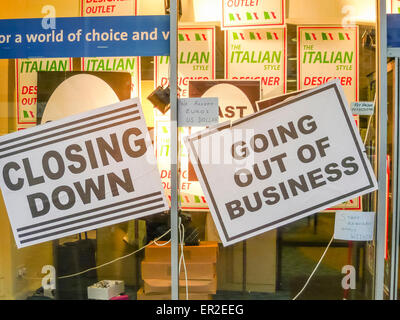 Signs in the window of a shop indicating the business of closing down. Stock Photo