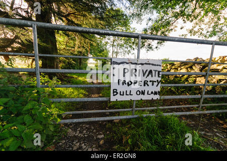 Sign warning the public that land is private property, and that a bull is on land. Stock Photo