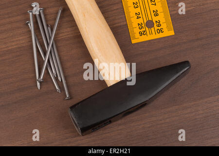 Hammer with ruler and nails on table Stock Photo