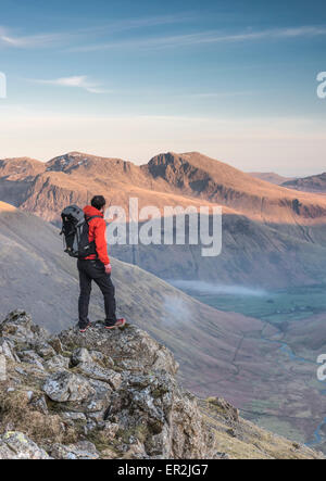 Hiker on Pillar at dusk in the English Lake District, with Mosedale, Scafell and Scafell Pike in the background Stock Photo