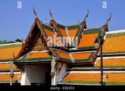 Bangkok, Thailand:  Steeply gabled roofs with gilded chofah ornaments over the cloister gallery at Wat Suthat Stock Photo
