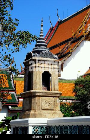 Bangkok, Thailand:  A marble tower with ringed chedi spire and Ubosot sanctuary hall roof with chofahs at Wat Pathum Wanaram Stock Photo