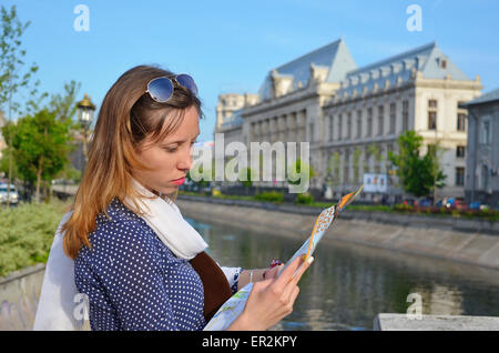 Young girl reading a map close to a river in Bucharest Stock Photo