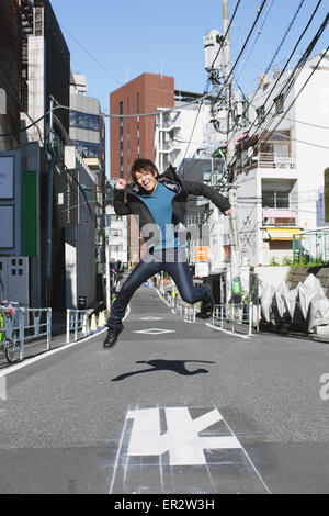 Young man jumping in an alley Stock Photo