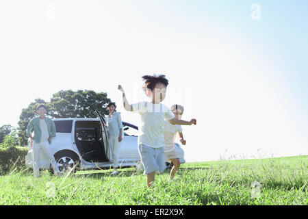 Happy Japanese family with car in a city park Stock Photo