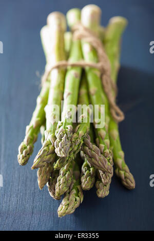 bunch of fresh asparagus on blue background Stock Photo