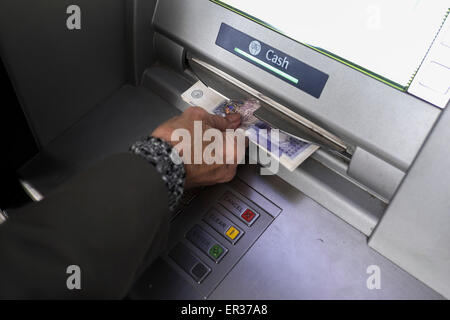 A customer withdrawing money from an ATM. Stock Photo