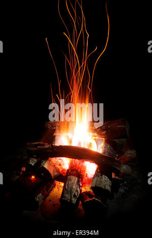 Flames and sparks of a wood camp fire at night (focus on flame) Stock Photo