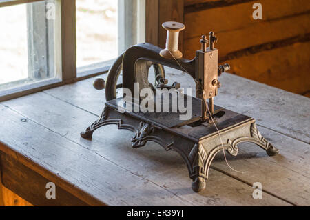 Old vintage sewing machine on wooden table Stock Photo