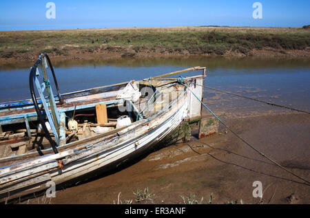 The stern of a deteriorating fishing boat in the small North Norfolk harbour at Thornham, Norfolk, England, United Kingdom. Stock Photo