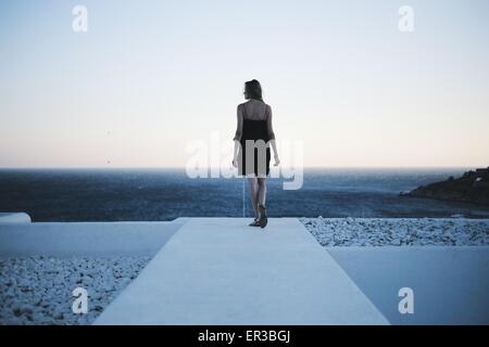Rear view of woman looking out to sea Stock Photo
