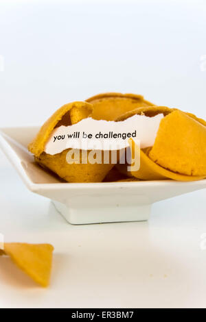open fortune cookie with strip of white paper - YOU WILL BE CHALLENGED Stock Photo