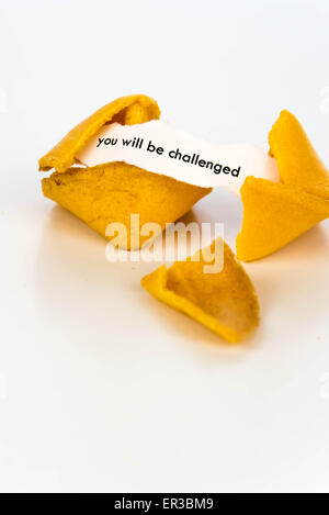 open fortune cookie with strip of white paper - YOU WILL BE CHALLENGED Stock Photo
