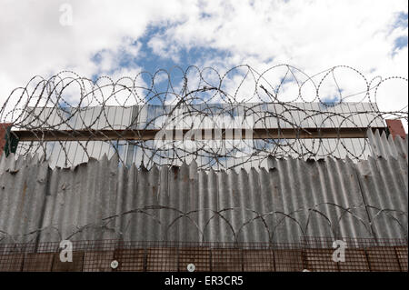 Galvanised high security razor wire and barbed wires deterrent to slow down climbing over walls with mass of corrugated spikes Stock Photo