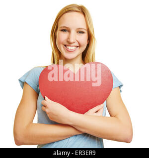 Girl embracing a big red heart as love symbol with her arms Stock Photo