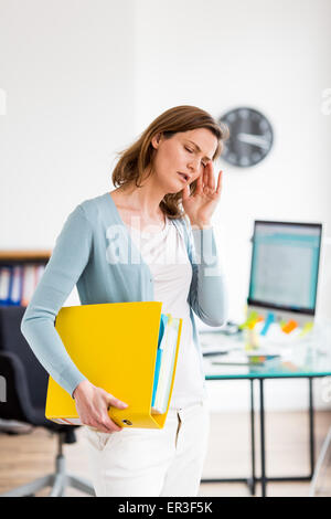 Woman at work suffering from headache. Stock Photo