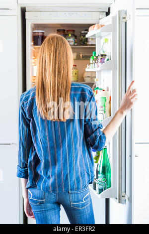 Woman in front of a refrigerator. Stock Photo