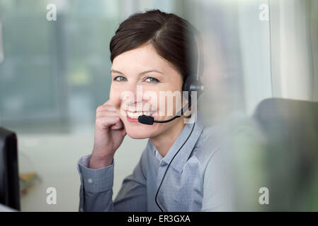 Businesswoman wearing headset during conference call, portrait Stock Photo