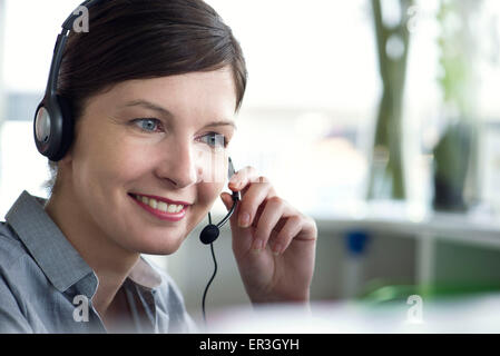 Receptionist using telephone headset Stock Photo