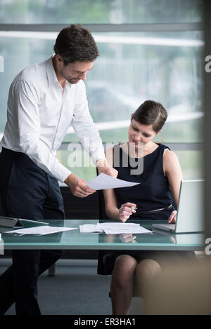 Businessman explaining document to colleague Stock Photo