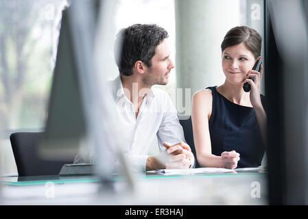 Businessman listening to associates phone call Stock Photo