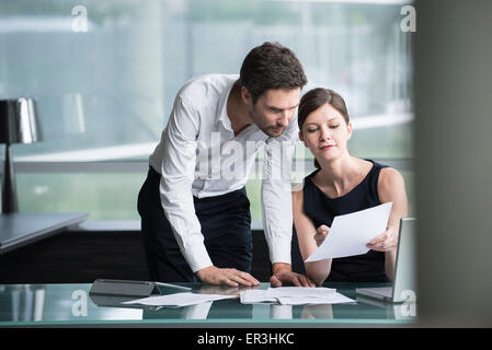 Businesswoman explaining document to associate Stock Photo