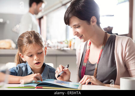 Mother and young daughter reading together Stock Photo