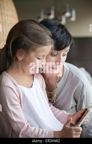 Mother and young daughter using digital tablet and making funny faces Stock Photo