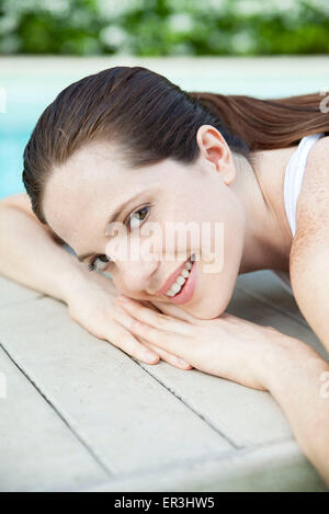 Young woman sunbathing with head resting on hands, portrait Stock Photo
