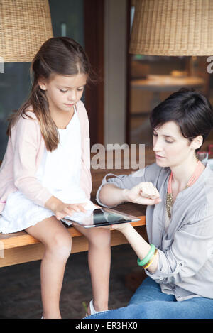 Mother and young daughter using digital tablet together Stock Photo