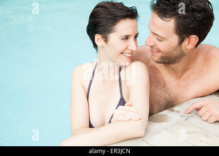 Couple relaxing together in pool Stock Photo