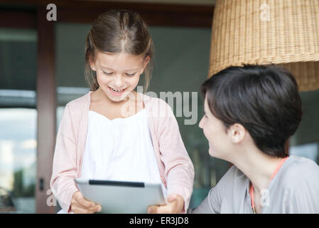 Mother and young daughter using digital tablet together Stock Photo