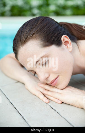 Young woman lying down, sunbathing with eyes closed, cropped Stock Photo