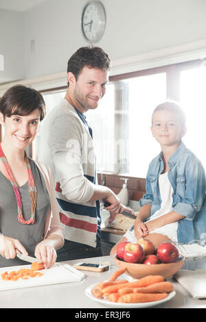 Family preparing food together in kitchen Stock Photo