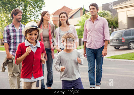 Family walking together through suburban neighborhood Stock Photo