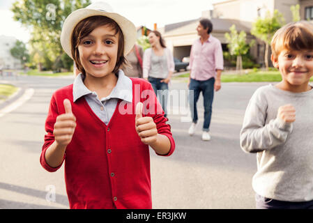 Boys playing outdoors, family in background Stock Photo