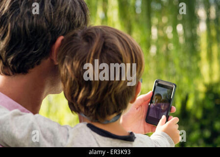 Father and son posing for photograph with smartphone Stock Photo