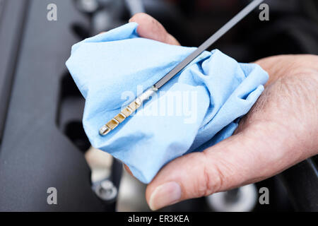 Close-Up Of Man Checking Car Engine Oil Level On Dipstick Stock Photo