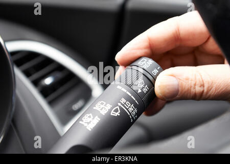 Close Up Of Hand Operating Windscreen Wiper Control In Car Stock Photo