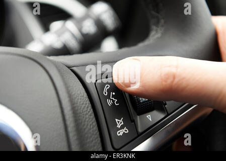 Close Up Of Hand Pressing Car Bluetooth Control On Steering Wheel Stock Photo