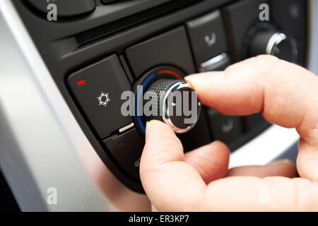 Close Up Of Hand Adjusting Car Air Conditioning Control On Dashboard Stock Photo