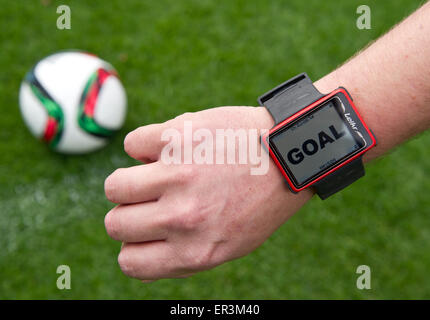 Berlin, Germany. 26th May, 2015. The goal line technology watch is used in conjunction with a football during a demonstration at the Olympiastadion in Berlin, Germany, 26 May 2015. The 'Hawk Eye' is a camera-based system that monitors the goal box from different angles using high-speed cameras. The information may be used to calculate the exact position of the football. The technology will be used during the upcoming final of the German football competition DFB Cup in Berlin on 30 May. PHOTO: ANNEGRET HILSE/dpa/Alamy Live News Stock Photo