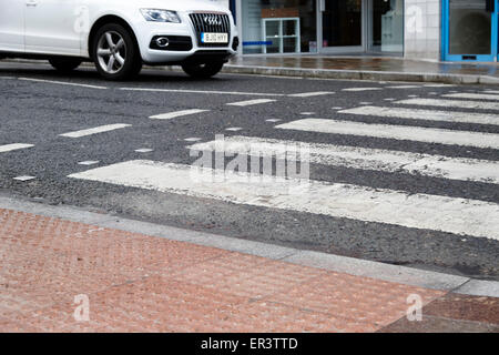 car waiting at textured pedestrian crossing pavement in the wet in the uk Stock Photo