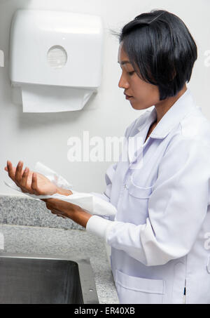 Woman in laboratory drying her wet hands Stock Photo