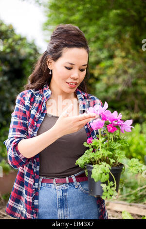 young woman holding a flower pot in the garden Stock Photo