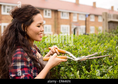 young woman cutting her hedge Stock Photo