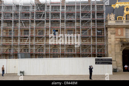 A worker with restoration and preservation scaffolding setting up on the exterior of the Château de Versailles, France Stock Photo