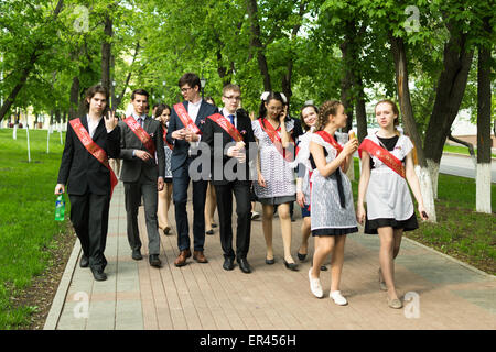 Group of Russian schoolchildren in traditional uniform celebrating graduation from high school in May 2015 Stock Photo