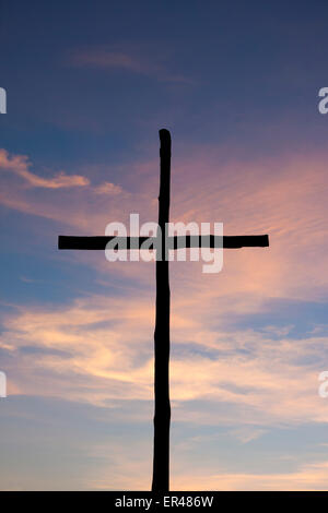 La Verna Franciscan monastery wooden cross silhouette against dramatic pink sunset sky  Arezzo Province Eastern Tuscany Italy Stock Photo